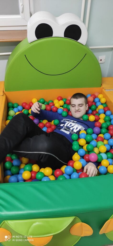 uczeń w basenie z piłeczkami